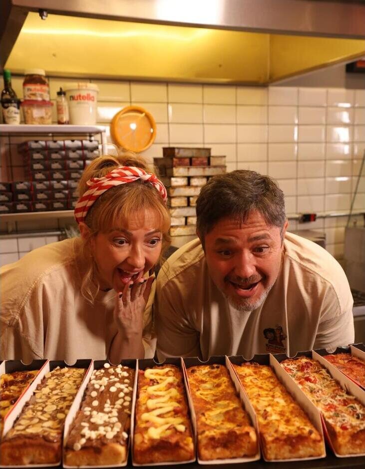 Casal de franqueados observando a fileira de pizzas Looong em uma unidade